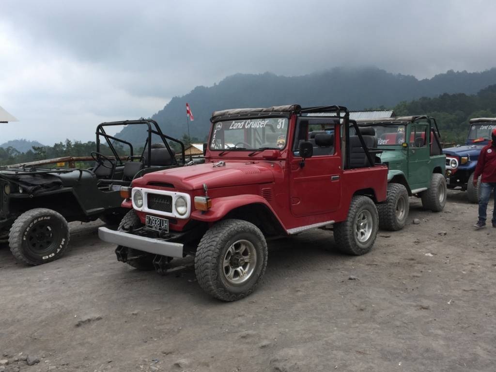 旅客乘吉普車，走破爛不堪的山路，去看火山肆虐痕跡。